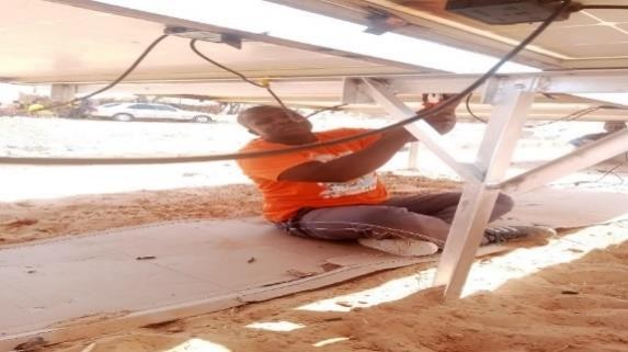 Cabling work beneath the array during the Garu village installation.